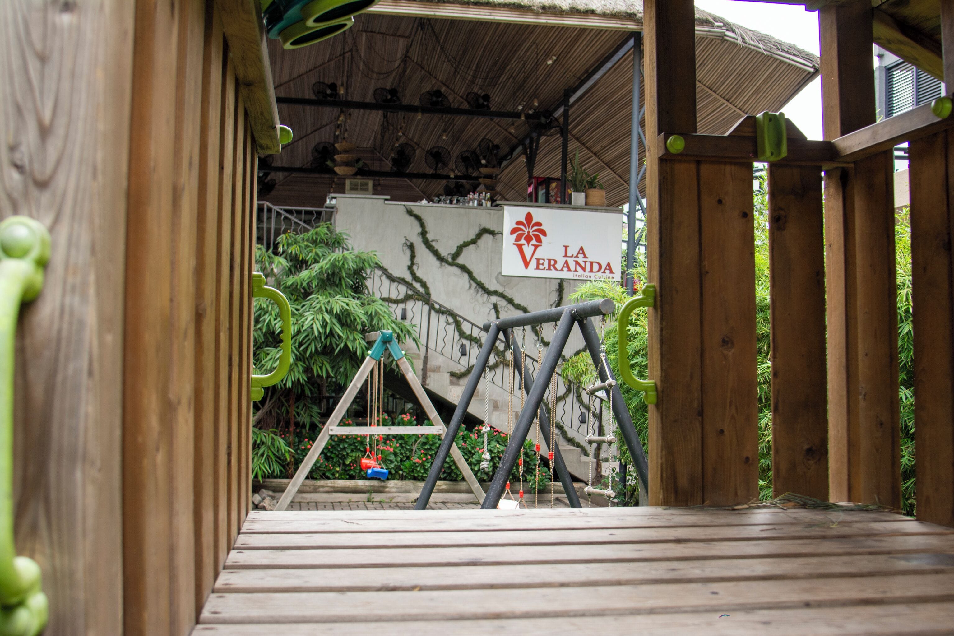A wooden deck with a sign for "La Veranda Italian Garden."