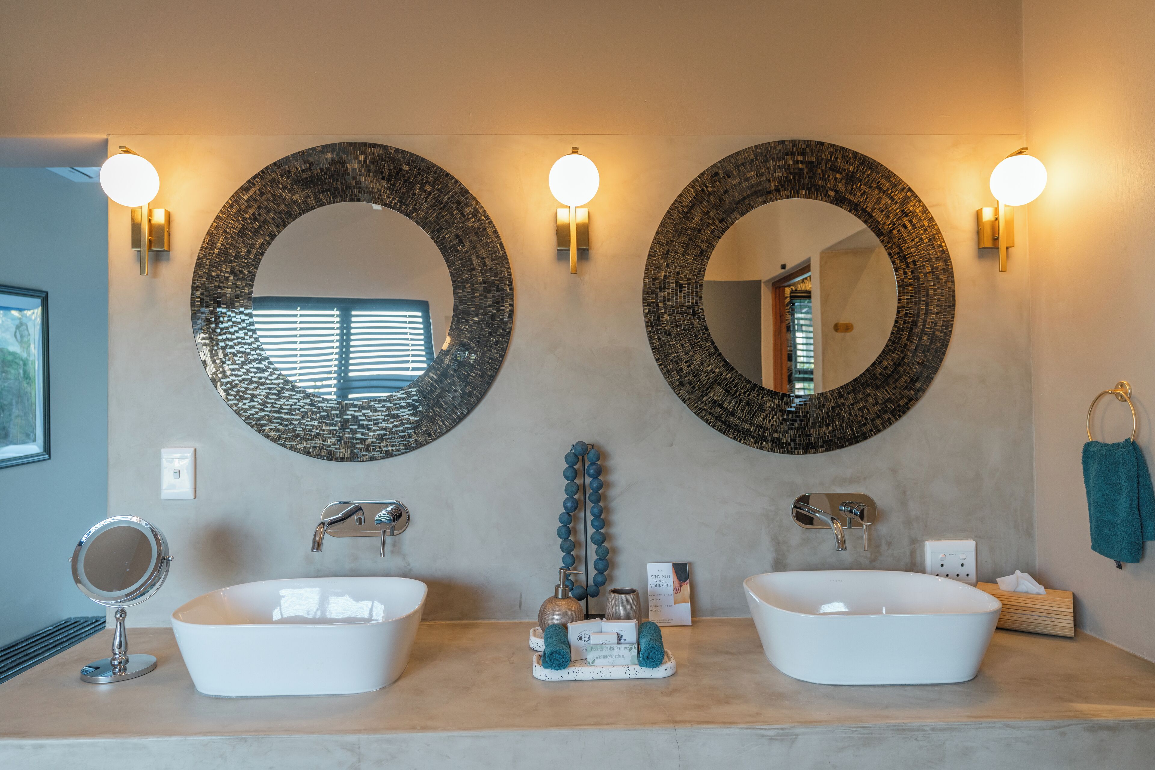 A bathroom with two sinks, two wall-mounted mirrors, and a towel rack.