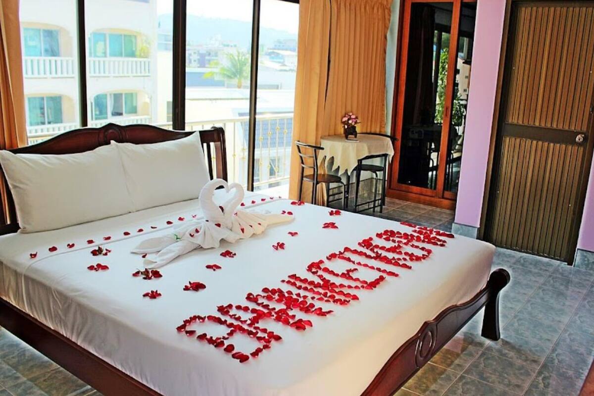 Une chambre d’hôtel avec un lit, une table et des chaises, et un balcon avec vue.