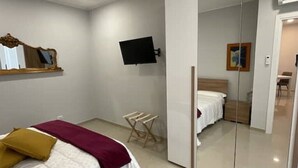 A bedroom with a bed, a TV mounted on the wall, and a mirror. - Apartment "ALFA" (Rho)