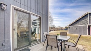 A modern building with a sliding glass door leading to an outdoor patio with a table and chairs. - Peyton's Place at Tamarack - Great Location! (Wisconsin Dells)