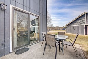 A modern building with a sliding glass door leading to an outdoor patio with a table and chairs. - Peyton's Place at Tamarack - Great Location! (Wisconsin Dells)