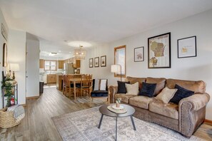 Un salon comprenant un canapé, une table basse et un coin repas avec des chaises et une table.
