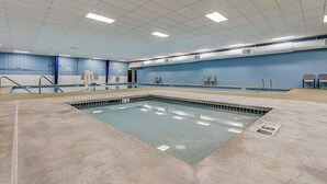 An indoor swimming pool with a tiled floor, a blue wall, and a ceiling with fluorescent lights. - Peyton's Place at Tamarack - Great Location! (Wisconsin Dells)