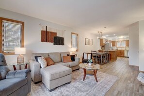 A living room with a sofa, armchairs, a coffee table, and a dining area with a table and chairs.