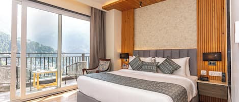 Un dormitorio moderno con una cama grande, un televisor y un balcón con vistas a las montañas.