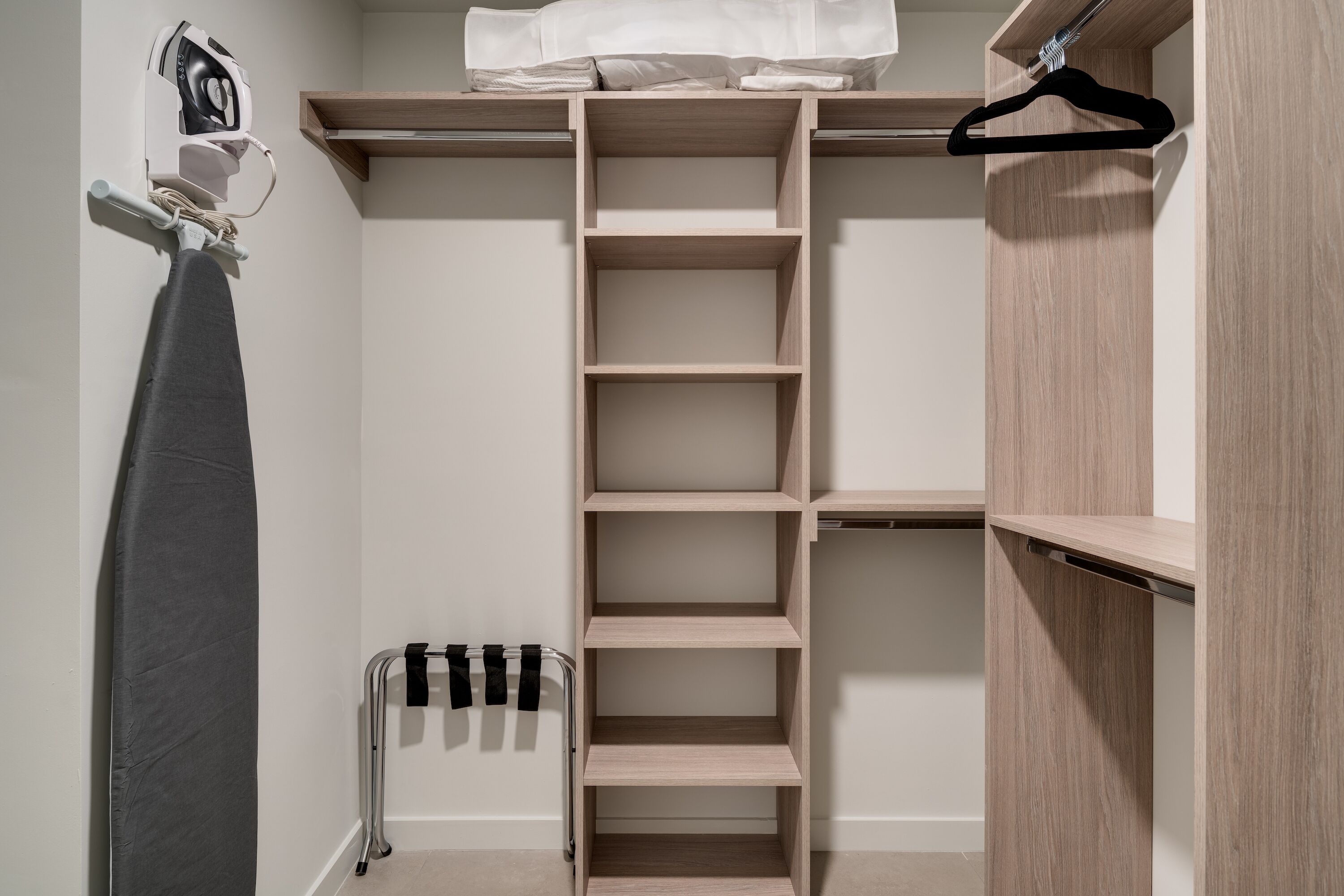 A walk-in closet with multiple shelves and hanging space.