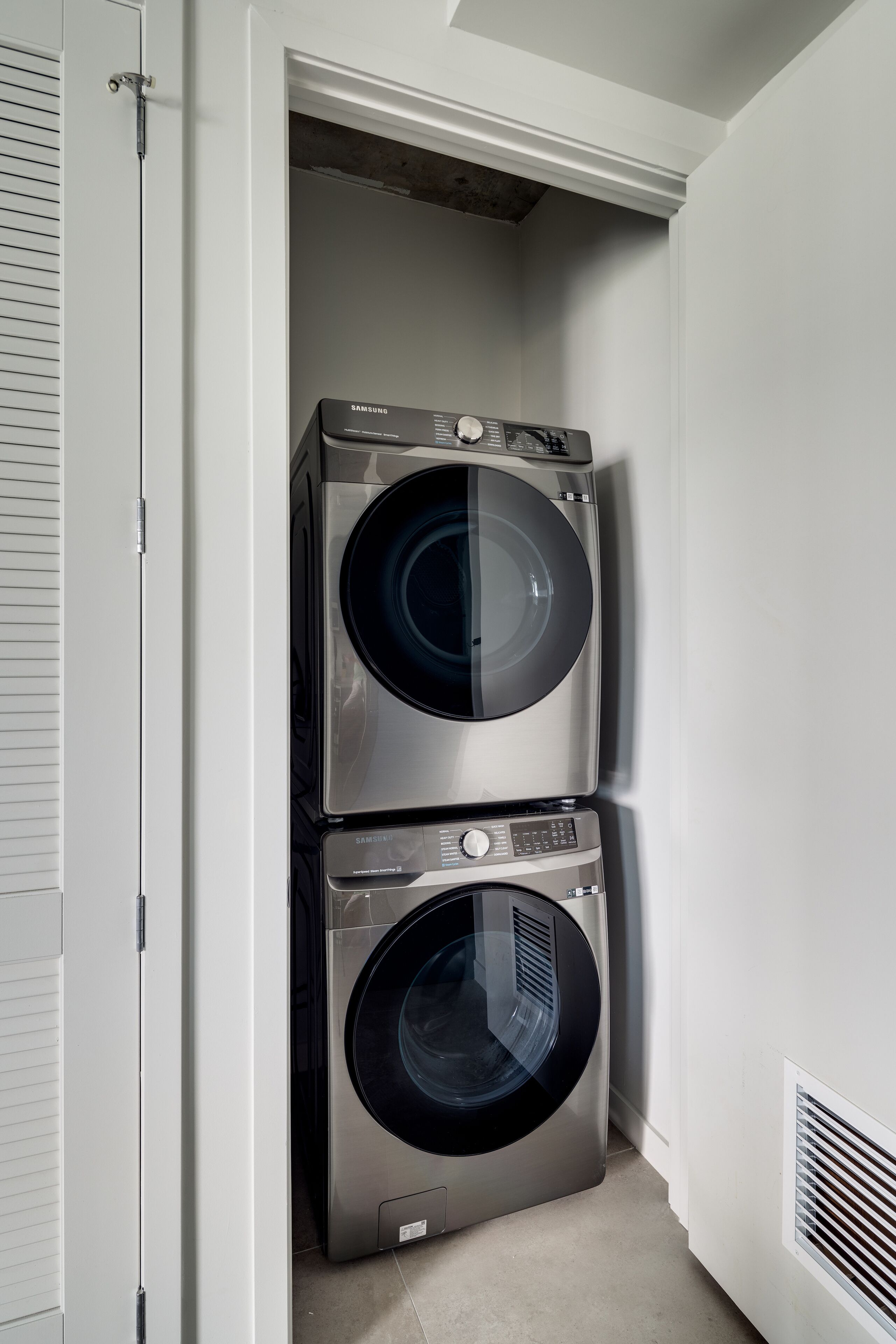 A laundry room with two stacked front-loading washing machines.