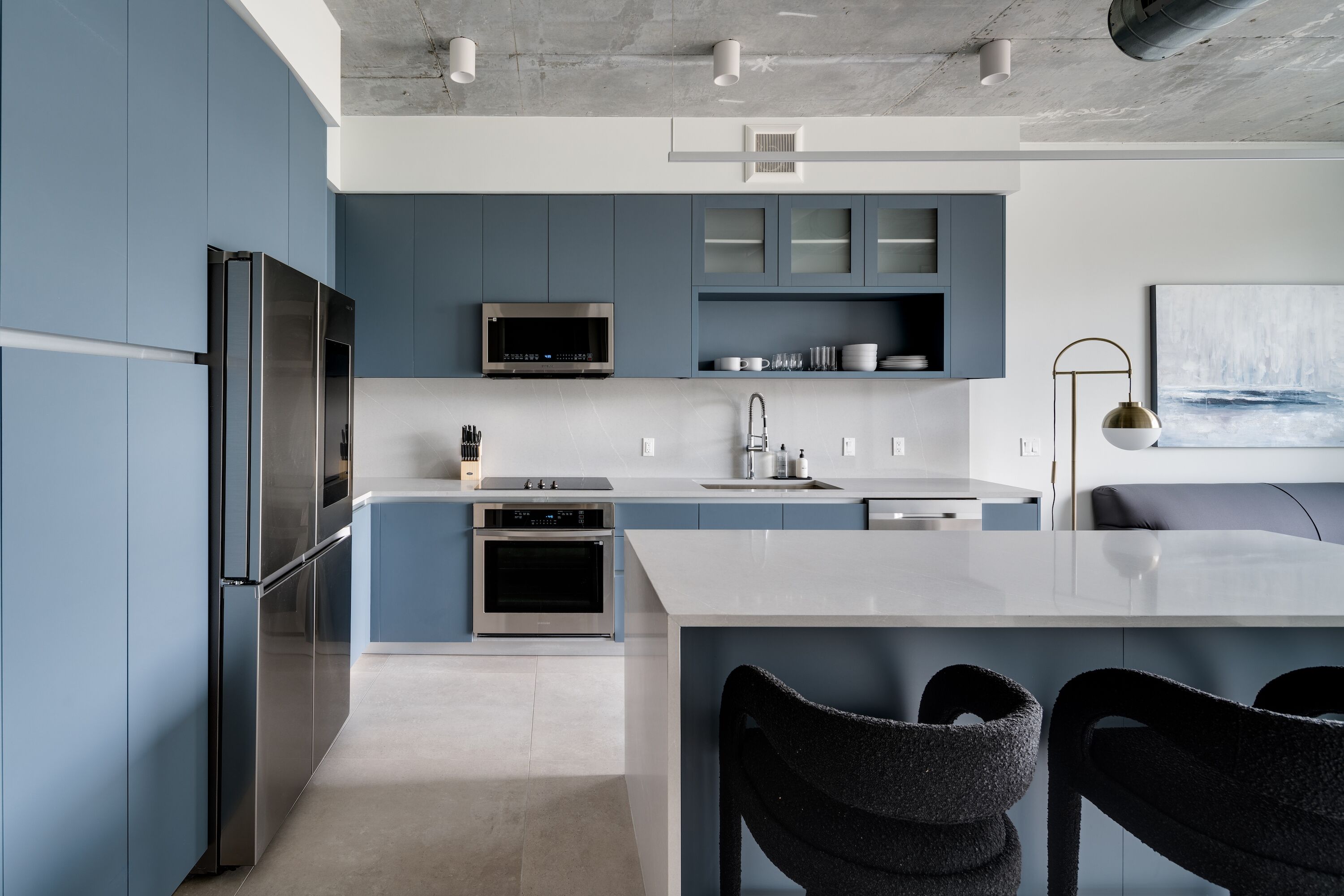 A modern kitchen with a large island, built-in appliances, and a minimalist design.