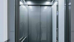 Un ascenseur doté d’un intérieur métallique et de portes en verre réfléchissant.