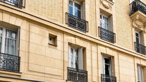 A multi-story building with a beige facade, black wrought iron balconies, and a gated entrance. - L'appartement Blomet  (Paris)