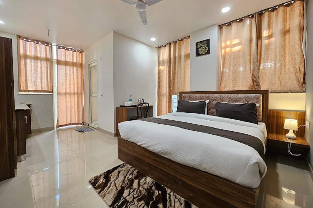 A modern bedroom with a large bed, a ceiling fan, and a desk with a chair.