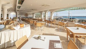 A restaurant with outdoor seating overlooking a scenic view, featuring a variety of dining tables and chairs. - Hotiday Leuca Lungomare (Castrignano del Capo)