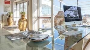 A hotel reception area with a glass desk, a computer monitor, and two large vases. - Hotiday Leuca Lungomare (Castrignano del Capo)