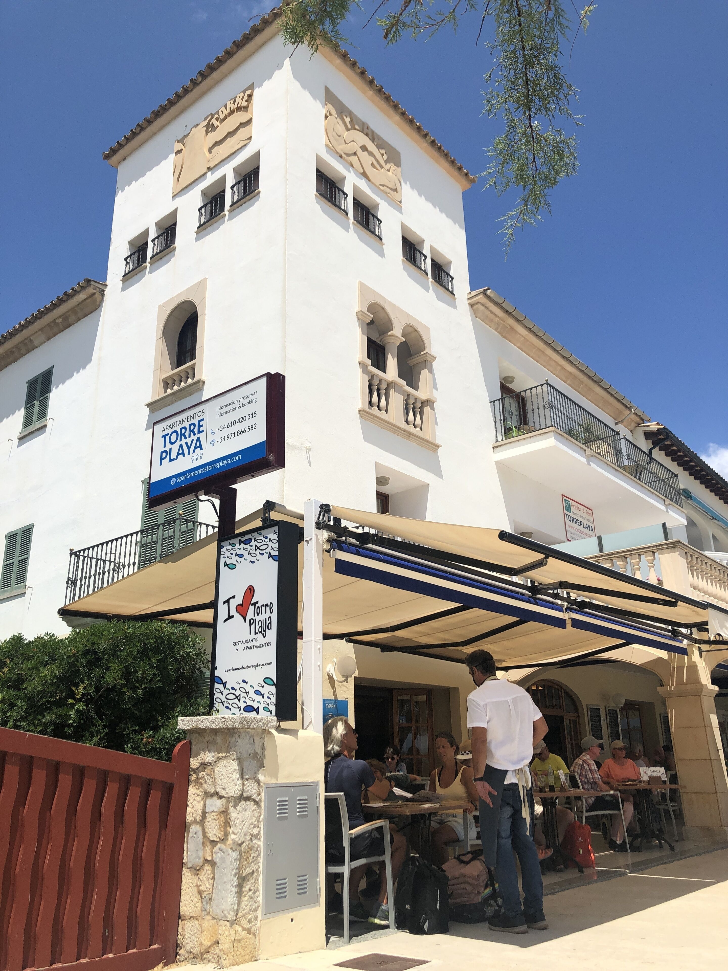 Un immeuble blanc doté de balcons et d’une enseigne indiquant « Appartements Torre Playa ».
