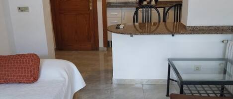 Une chambre d’hôtel comprenant un lit, un canapé, une petite table et une kitchenette.