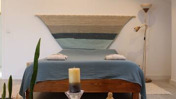Cozy retreat with a large bed, decorative wall hanging, and stylish floor lamp.