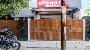 A hotel entrance with a wooden gate, a motorcycle parked outside, and a sign for OYO Hotel. - Umen Hotel Sector 66 (Noida)