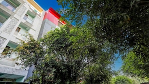 A multi-story building with balconies and a red roof. - Umen Hotel Sector 66 (Noida)