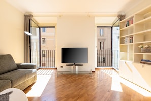 A modern living room with a flat-screen TV, a sofa, and a bookshelf. - Your amazing holiday in the heart of the Jewish Ghetto
 (Roma)