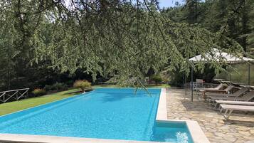 En sÀsongsöppen utomhuspool och solstolar