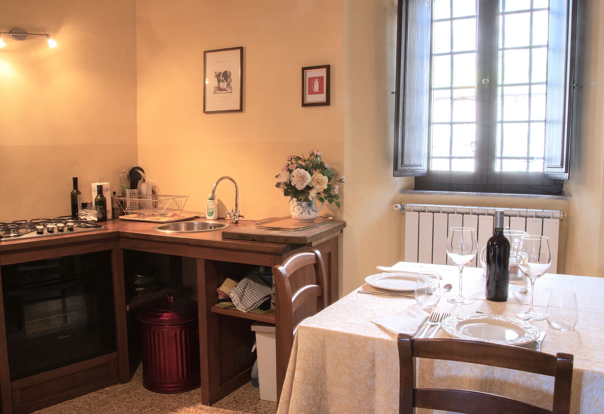 A kitchen with a dining area, a stove, sink, and a window with a view.
