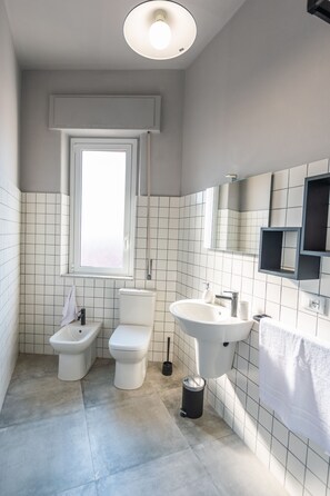 Ein modernes Badezimmer mit Toilette, Bidet und Waschbecken.
