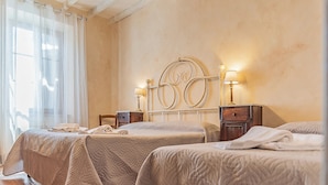 A hotel room with two beds, a wooden headboard, bedside lamps, and a large window with sheer curtains. - Agriturismo La Ripolina (Buonconvento)