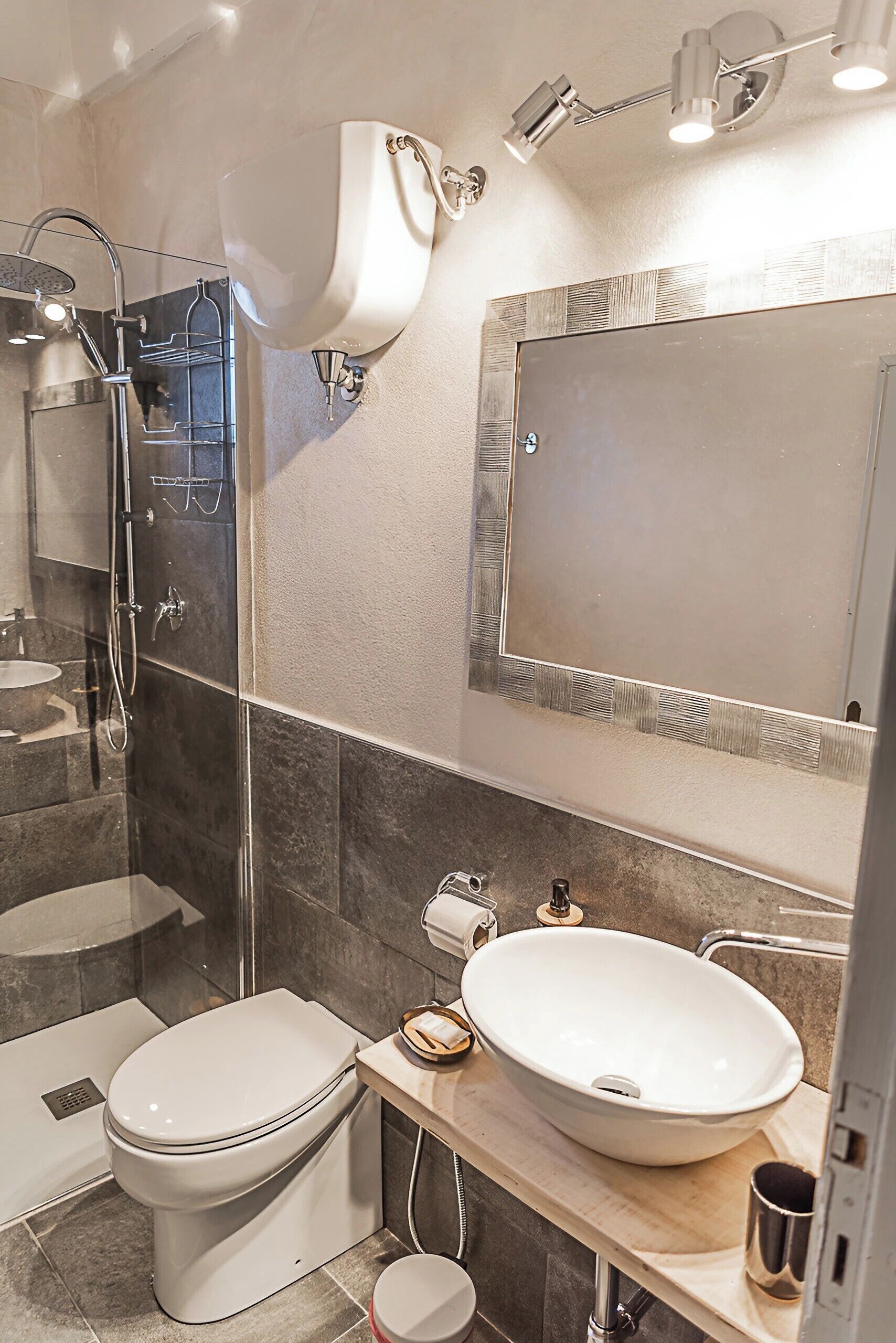 A modern bathroom with a glass-enclosed shower, a large mirror, and a white sink.