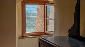 A room with a window overlooking a brick wall and a view of the countryside. - Agriturismo La Ripolina (Buonconvento)