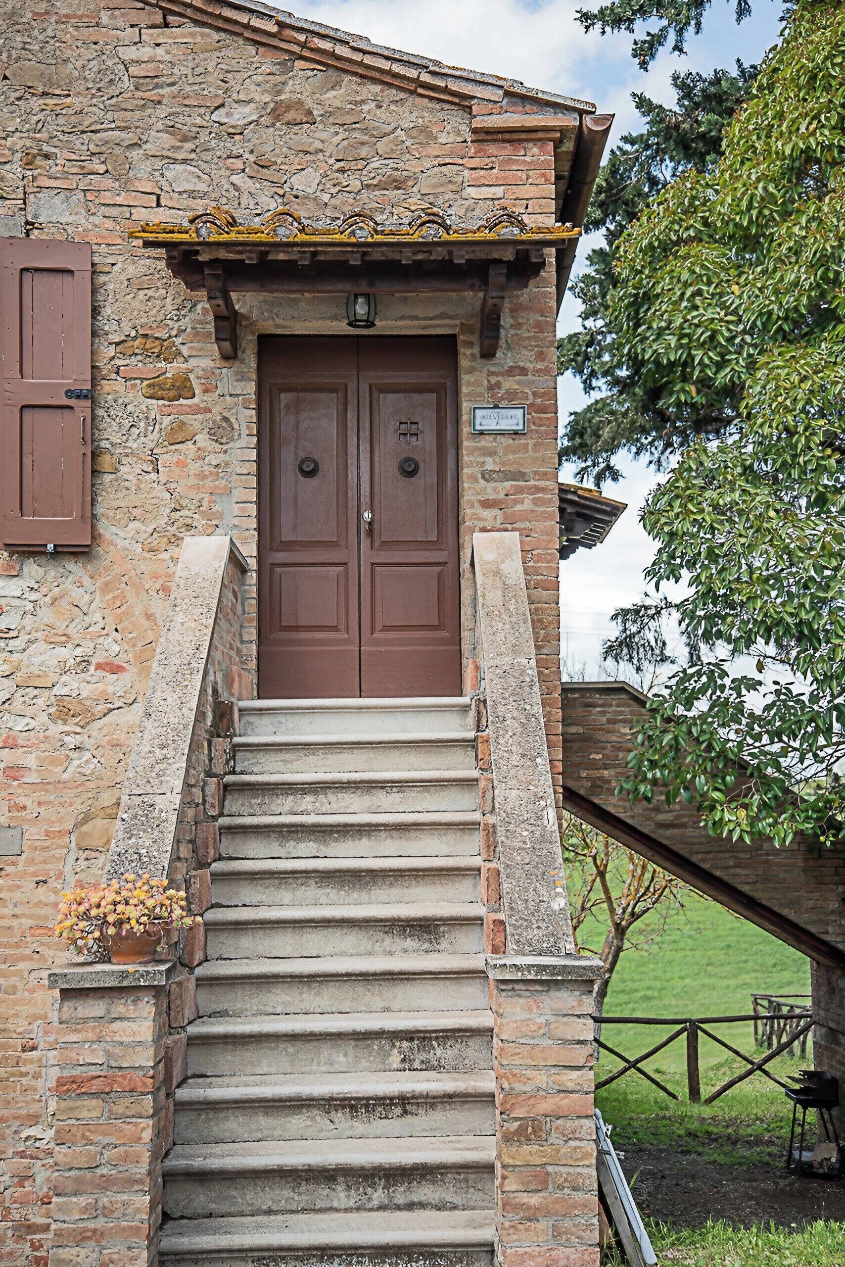 Un edificio de piedra con una puerta de madera y escalones que conducen a un porche.