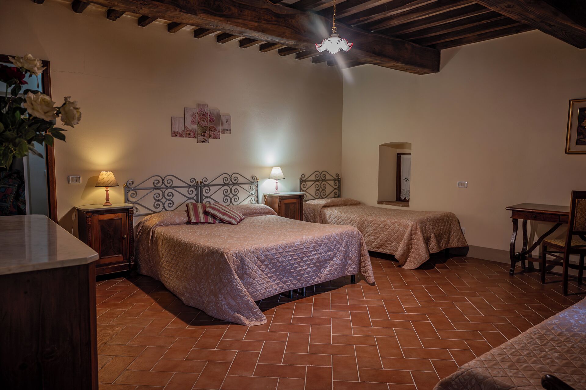 A bedroom with two beds, a desk, and a chair.
