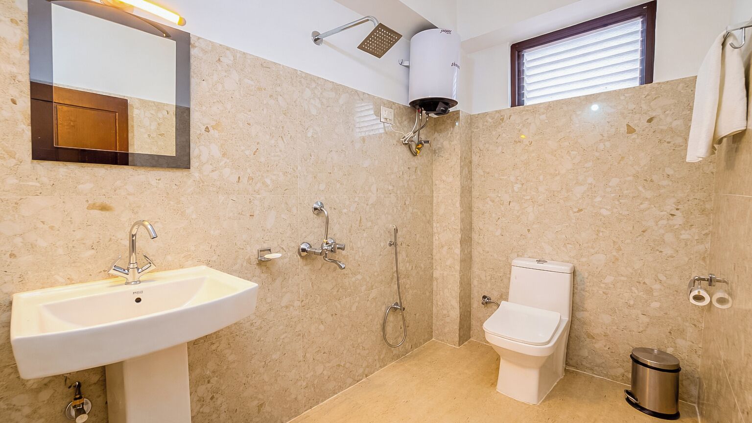 A bathroom with a sink, toilet, shower, and mirror.