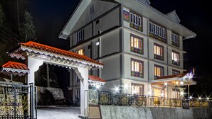 A multi-story hotel with a traditional architectural style, featuring balconies and a well-lit facade. - Sumitel Sonam Lachung (Chungthang)