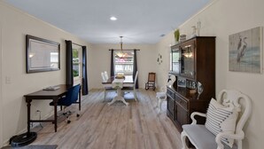 Un amplio espacio de sala con una mesa de comedor, un sofá y un armario.