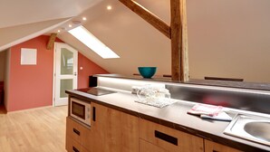 A kitchen with a wooden countertop, a sink, and a skylight. - Apartmány Adam (Jachymov)