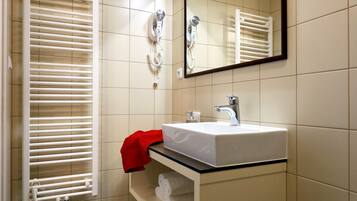 A bathroom with a white sink, mirror, and towel rack.
