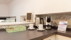 A hotel kitchen with a coffee maker, a kettle, and a coffee pot on the counter. - Il Camino Felice - 201 Autodromo F1 Villa Reale (Monza)
