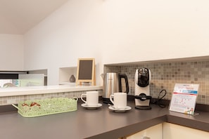 A hotel kitchen with a coffee maker, a kettle, and a coffee pot on the counter. - Il Camino Felice - 201 Autodromo F1 Villa Reale (Monza)