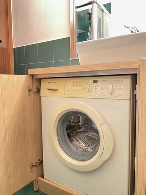 A Bosch washing machine in a bathroom with a wooden cabinet and green tiles. - Il Camino Felice - 201 Autodromo F1 Villa Reale (Monza)
