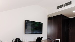 A modern office space with a desk, chair, laptop, and a white suitcase. - Green Krupnicza (Kraków)