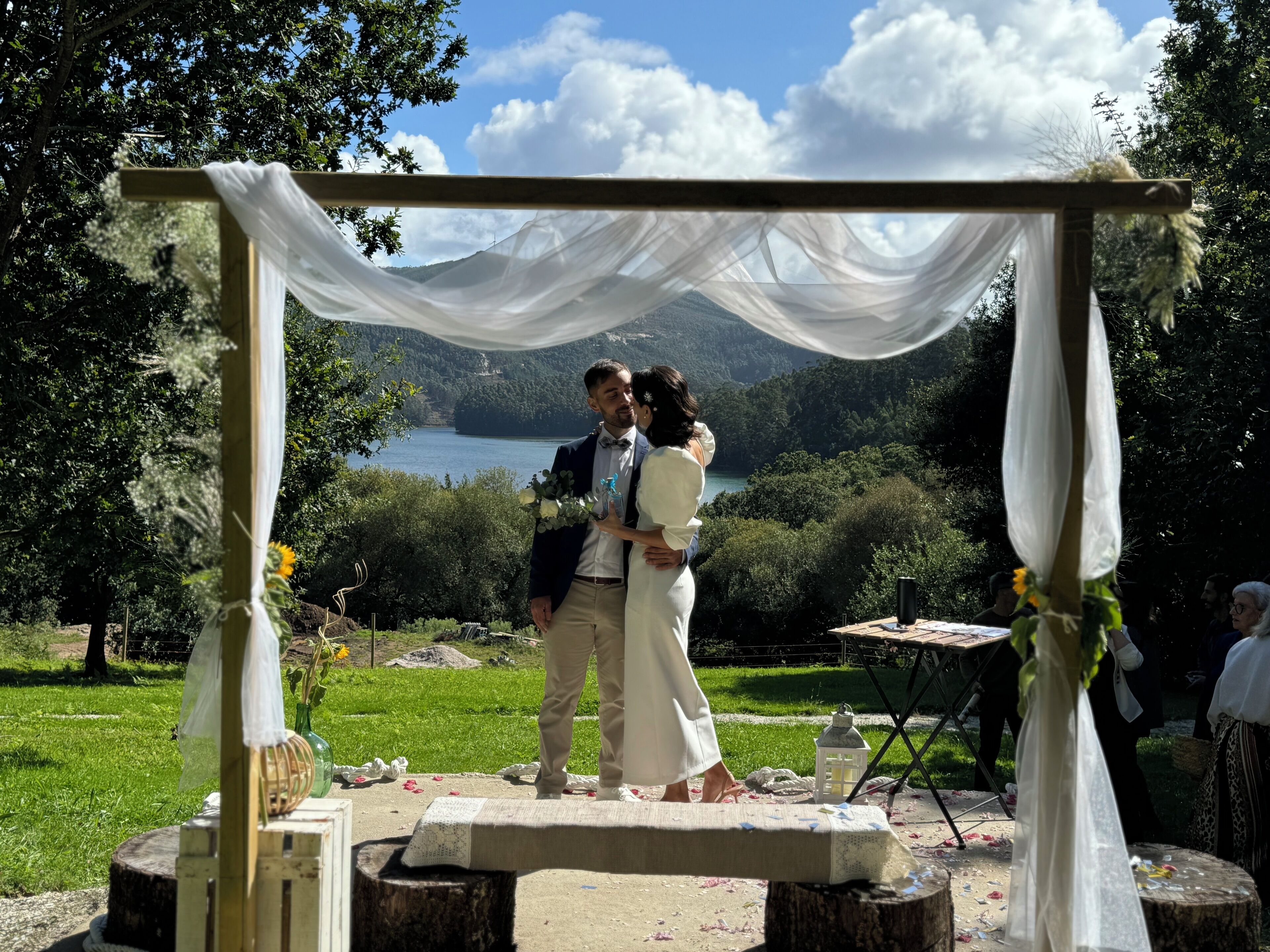 Une cérémonie de mariage se déroulant avec, en toile de fond, un lac et des montagnes.