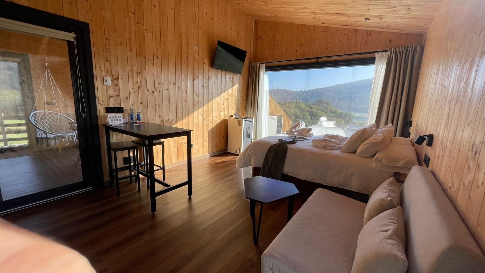 Une pièce en bois avec un lit, un bureau et une chaise.