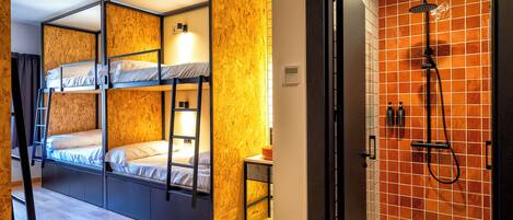 A bunk bed room with a wooden wall and a shower area with orange tiles.