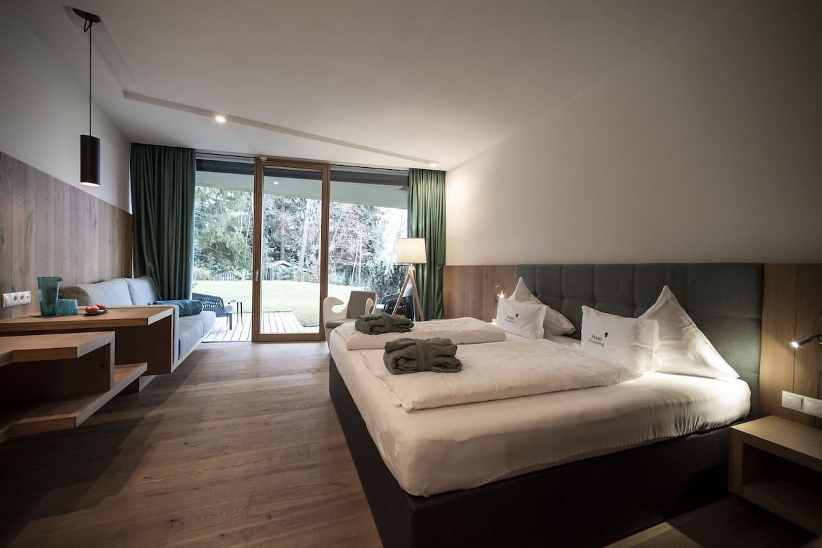 Una habitación de hotel moderna con una cama grande, un escritorio y vistas al exterior.