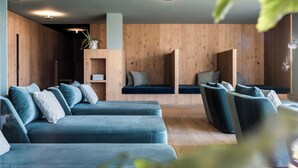 Un interior moderno con una pared de madera, un conjunto de sofá azul y una planta pequeña.