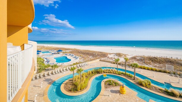 A resort with a pool area, beach, and ocean view.