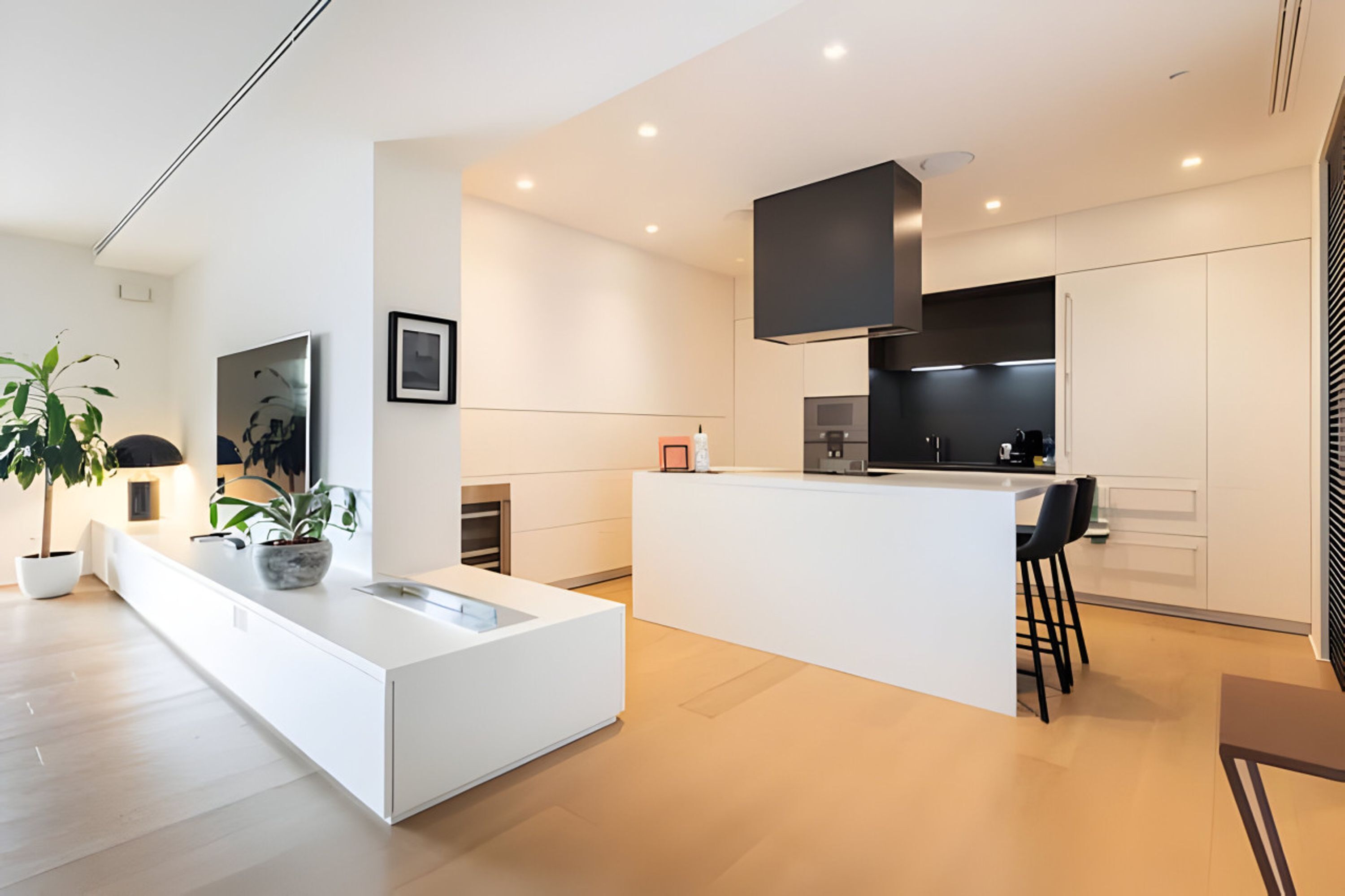 A modern kitchen with a central island, white cabinetry, and black appliances.