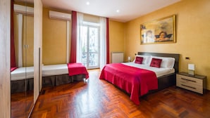 A hotel room with a large bed, a bedside table, a nightstand, a window with curtains, and a door. - Rosaroll 70 Apartment by Wonderful Italy (Naples)