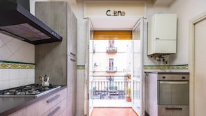 A kitchen with a gas stove, oven, and a built-in dishwasher. - Rosaroll 70 Apartment by Wonderful Italy (Naples)